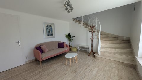 Hall d'entrée de la maison : canapé, meuble à chaussures et escalier en marbre avec rampe en fer forgé