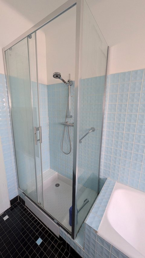 Douche à l'italienne avec paroi vitrée et pommeau réglable de la salle de bain