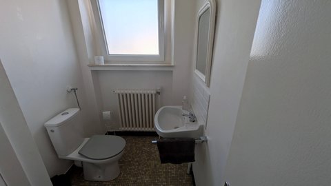 WC séparé indépendant au fond du couloir, avec lave-mains et fenêtre